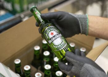 An employee carries out quality checks on a Heineken beer bottle on a packaging conveyor at the Heineken NV brewery in Zoeterwoude, Netherlands, on Wednesday, May 30, 2018. Heineken has acquired Stellenbrau, a beer maker based in South Africa's western Cape, submitted a bid for a local Coca-Cola bottler and built a brewery in Ivory Coast to take on market leader Castel. Photographer: Jasper Juinen/Bloomberg