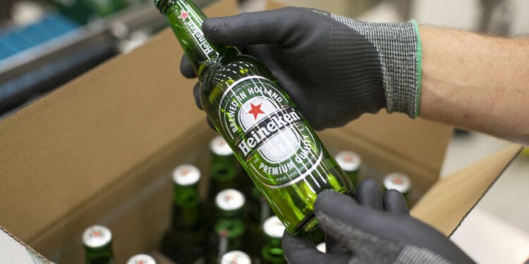 An employee carries out quality checks on a Heineken beer bottle on a packaging conveyor at the Heineken NV brewery in Zoeterwoude, Netherlands, on Wednesday, May 30, 2018. Heineken has acquired Stellenbrau, a beer maker based in South Africa's western Cape, submitted a bid for a local Coca-Cola bottler and built a brewery in Ivory Coast to take on market leader Castel. Photographer: Jasper Juinen/Bloomberg