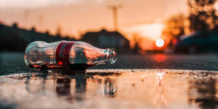coca-cola bottle on grey pavement