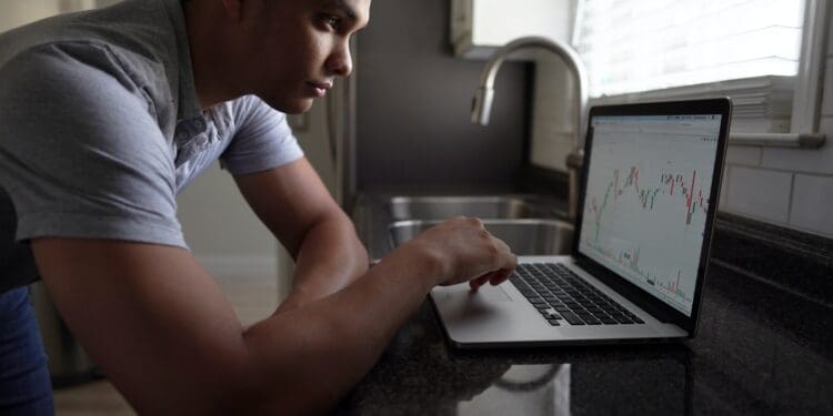 man in gray t-shirt using macbook pro