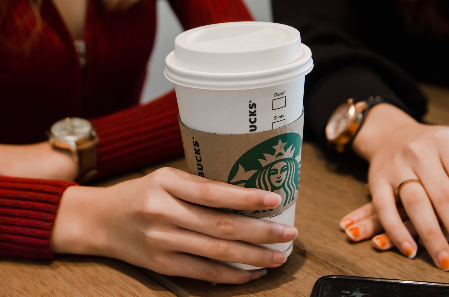 person holding white starbucks cup