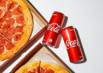 coca cola cans beside pizza