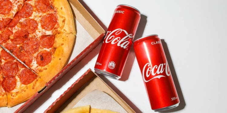 coca cola cans beside pizza