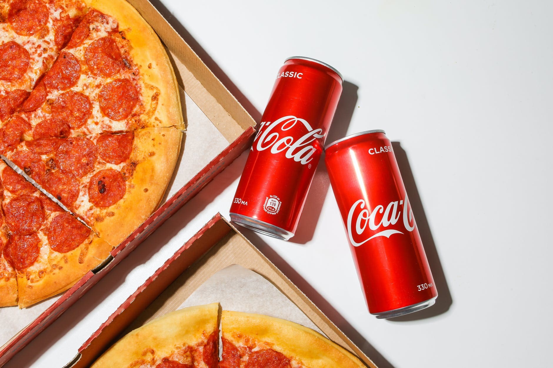 coca cola cans beside pizza