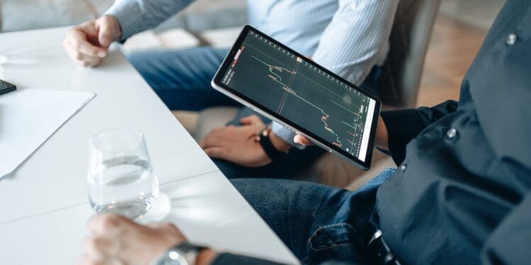 person holding black ipad with graph on screen