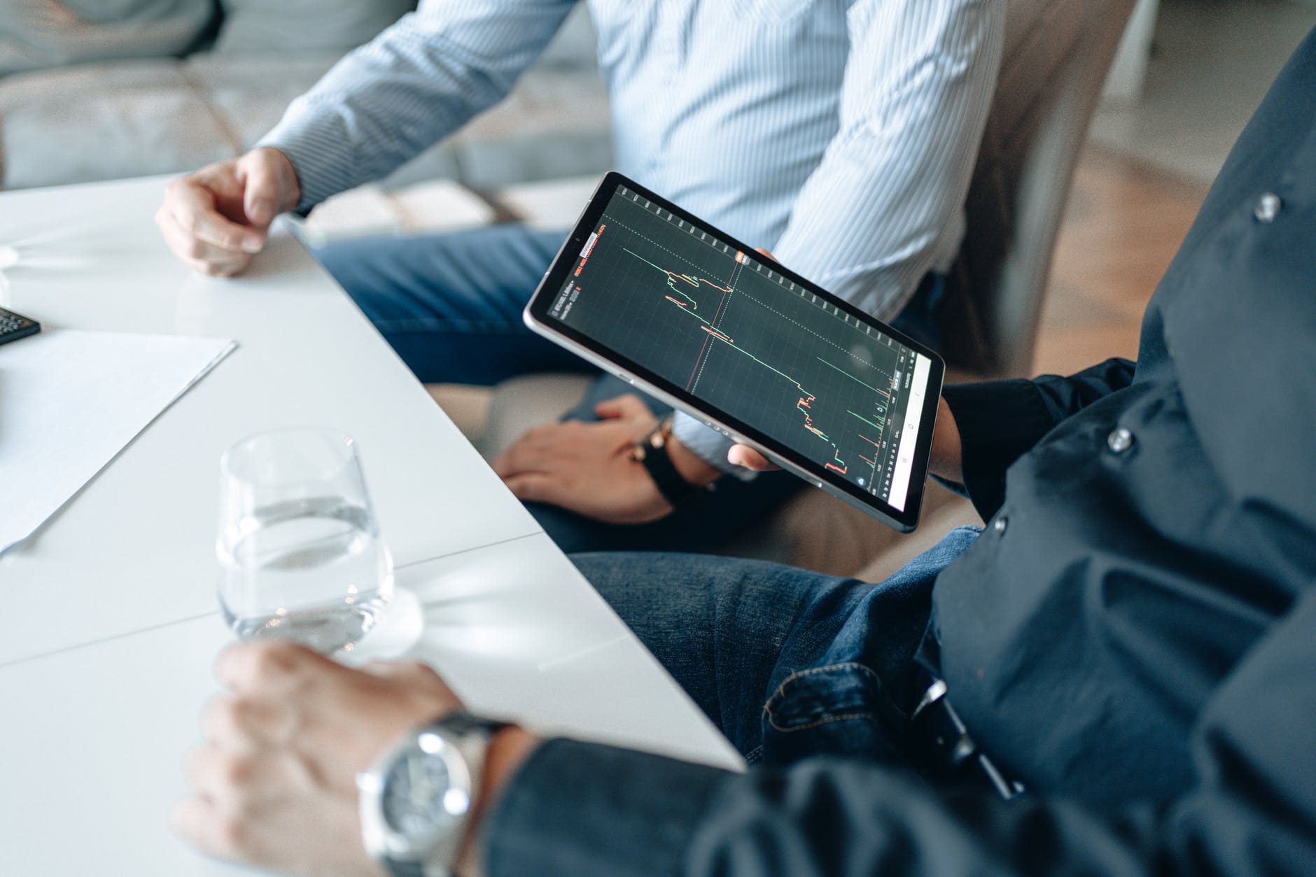 person holding black ipad with graph on screen