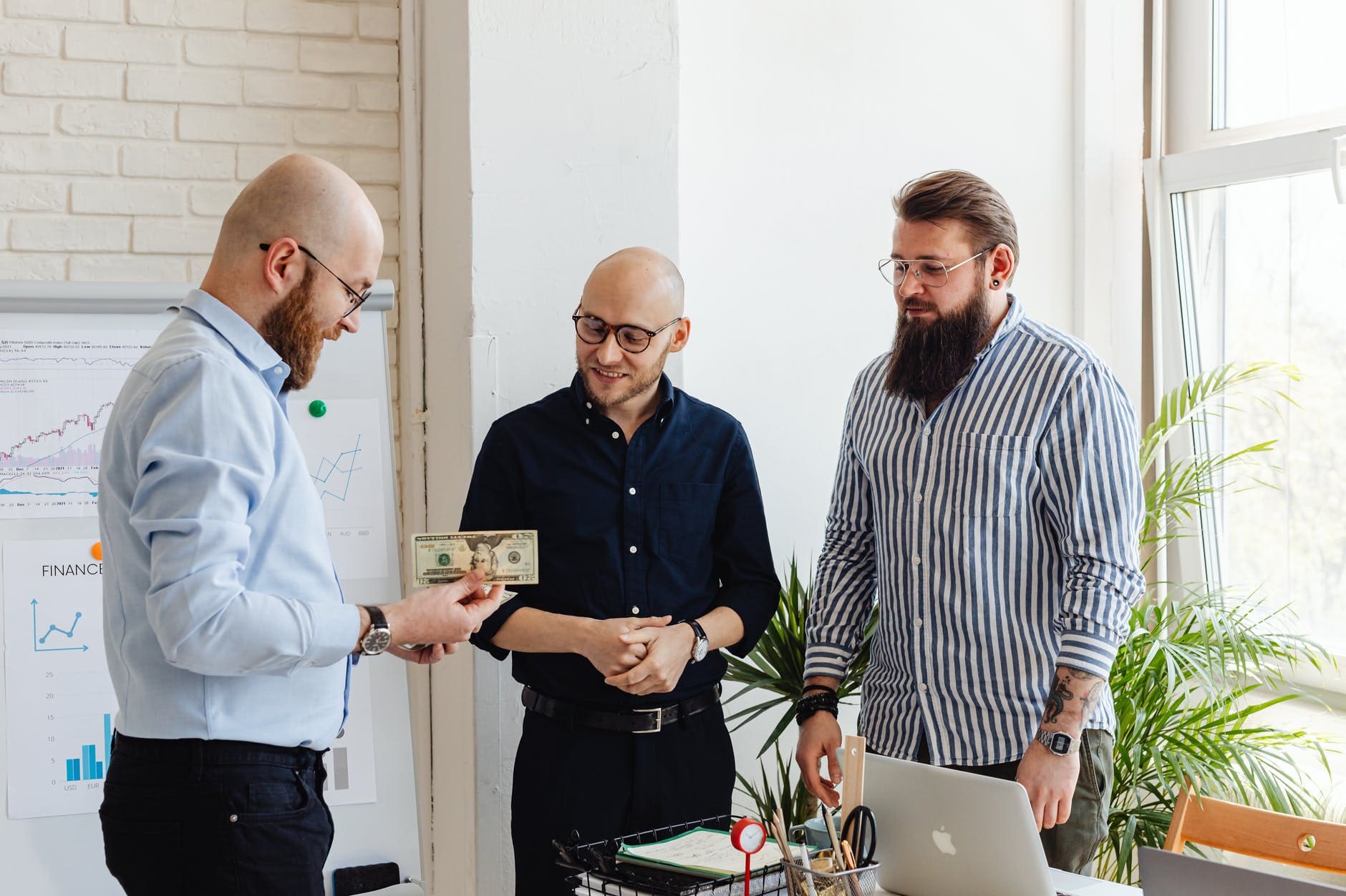 men standing looking at the money
