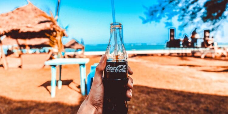 person holding coca cola glass bottle
