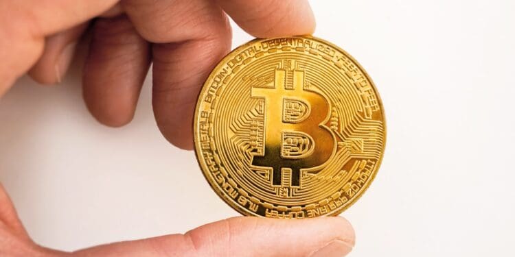 gold round coin on persons hand