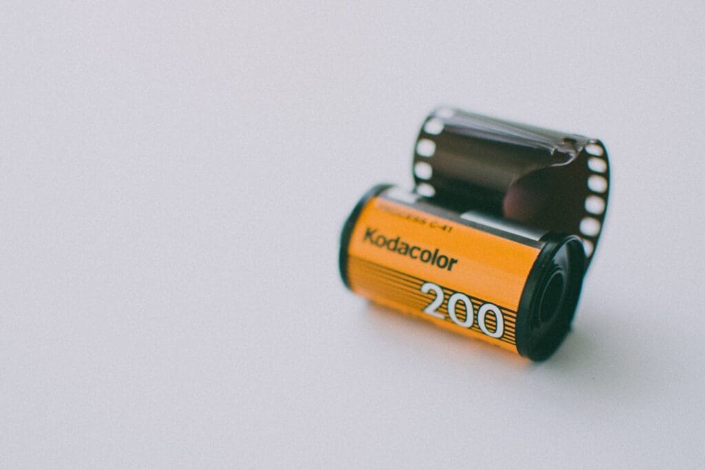Roll of Kodak Gold Analogue Camera Film on a Light Blue Background