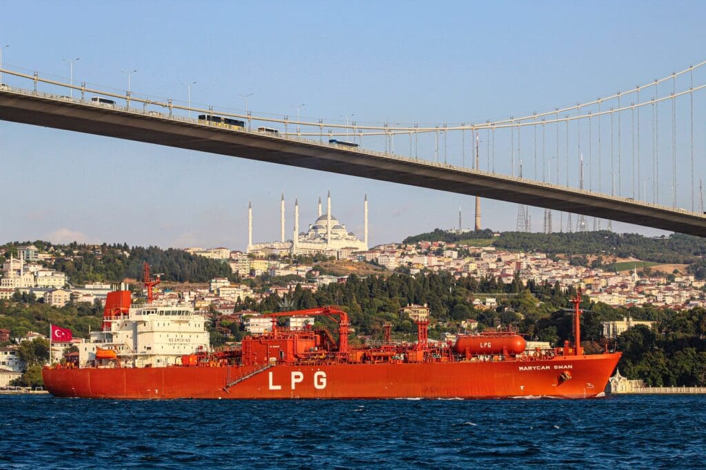 red LPG ship under bridge