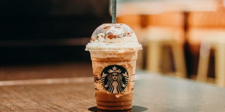 white and brown starbucks coffee cup on brown wooden table