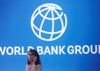 FILE PHOTO: A participant stands near a logo of World Bank at the International Monetary Fund - World Bank Annual Meeting 2018 in Nusa Dua, Bali, Indonesia, October 12, 2018. REUTERS/Johannes P. Christo/File Photo