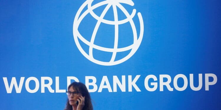 FILE PHOTO: A participant stands near a logo of World Bank at the International Monetary Fund - World Bank Annual Meeting 2018 in Nusa Dua, Bali, Indonesia, October 12, 2018. REUTERS/Johannes P. Christo/File Photo
