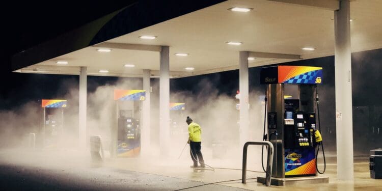 man in yellow jacket standing near gas pump