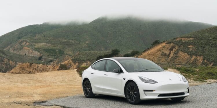 white sedan parked beside mountain during daytime