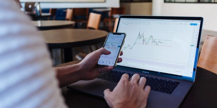 person using smartphone and MacBook Pro