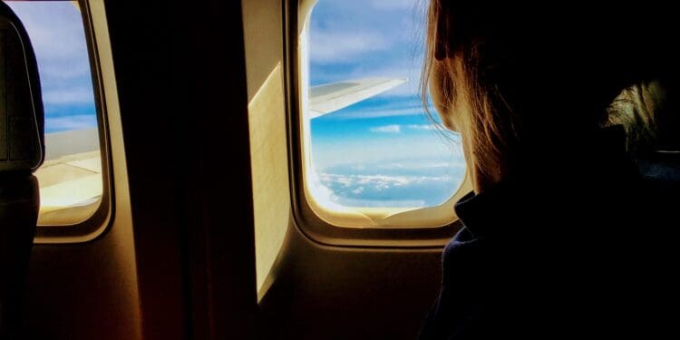 person looking outside of airplane window