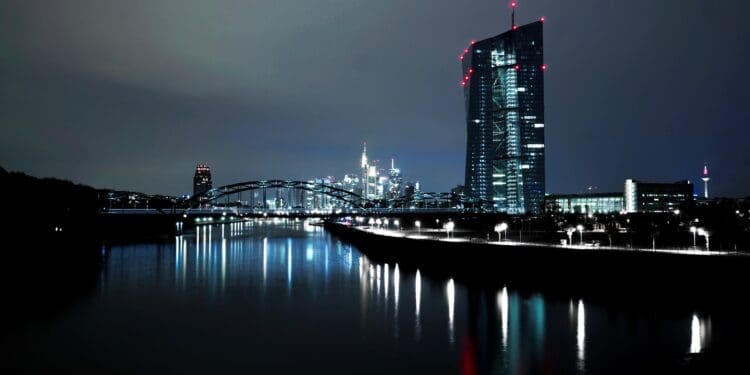 lighted high rise building near body of water at nighttime