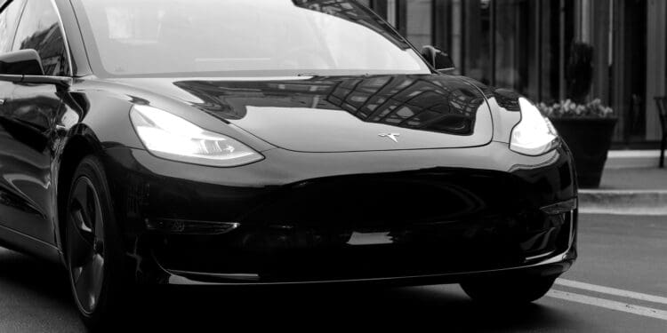 grayscale photography of Grand tourer parking near road