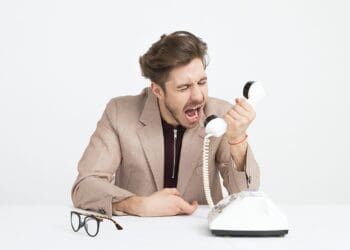 man holding telephone screaming