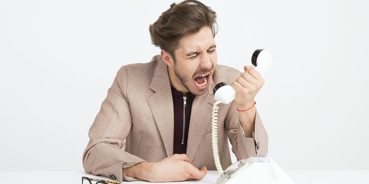 man holding telephone screaming