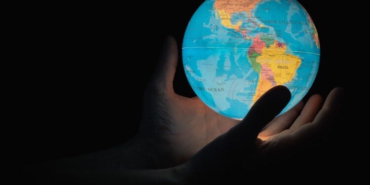 blue and brown globe on persons hand