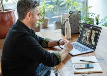 man in black sweater using macbook pro