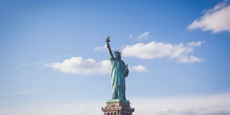 Statue of Liberty, New York under white and blue cloudy skies