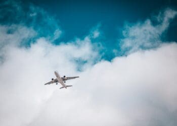 white airplane under blue sky and white clouds during daytime
