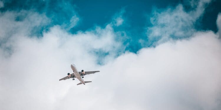 white airplane under blue sky and white clouds during daytime