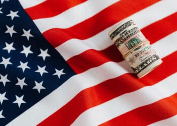 American flag with rolled dollar bills