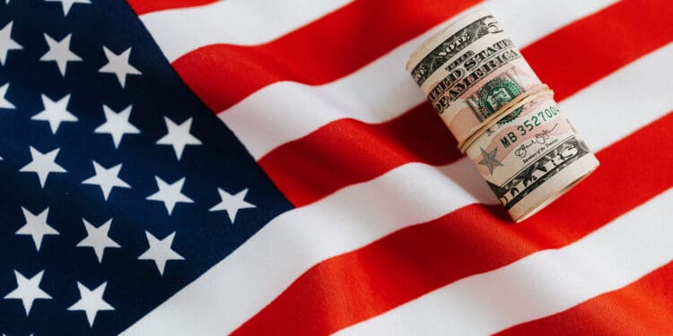 American flag with rolled dollar bills