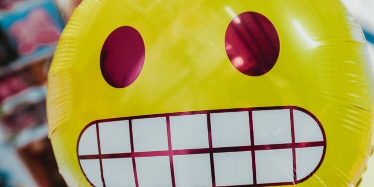 yellow inflatable smiling emoji balloon in focus photography