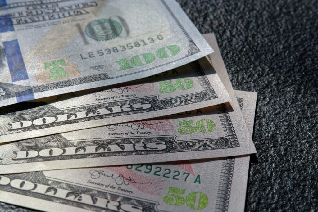 Close up of 100 and 50 US Dollar bills on black background