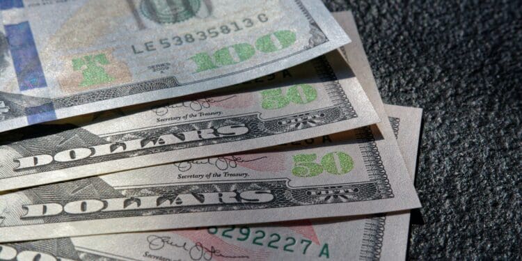 Close up of 100 and 50 US Dollar bills on black background