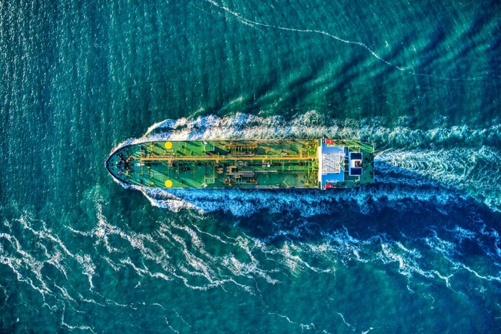 Green oil tanker headed out to sea aerial