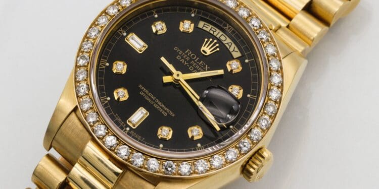 Mens 18K yellow gold president date/just Rolex with diamond bezel and diamond markers on black dial.