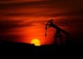 Pump-jack mining crude oil with the sunset