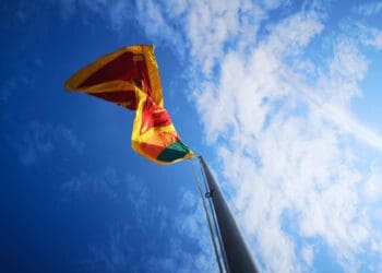 yellow, red, and green flag on pole under daylight