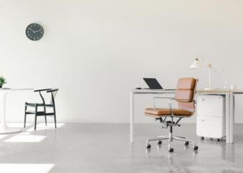 An open floor plan office space with a minimalist setup of chairs and desks.