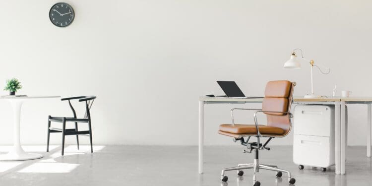 An open floor plan office space with a minimalist setup of chairs and desks.