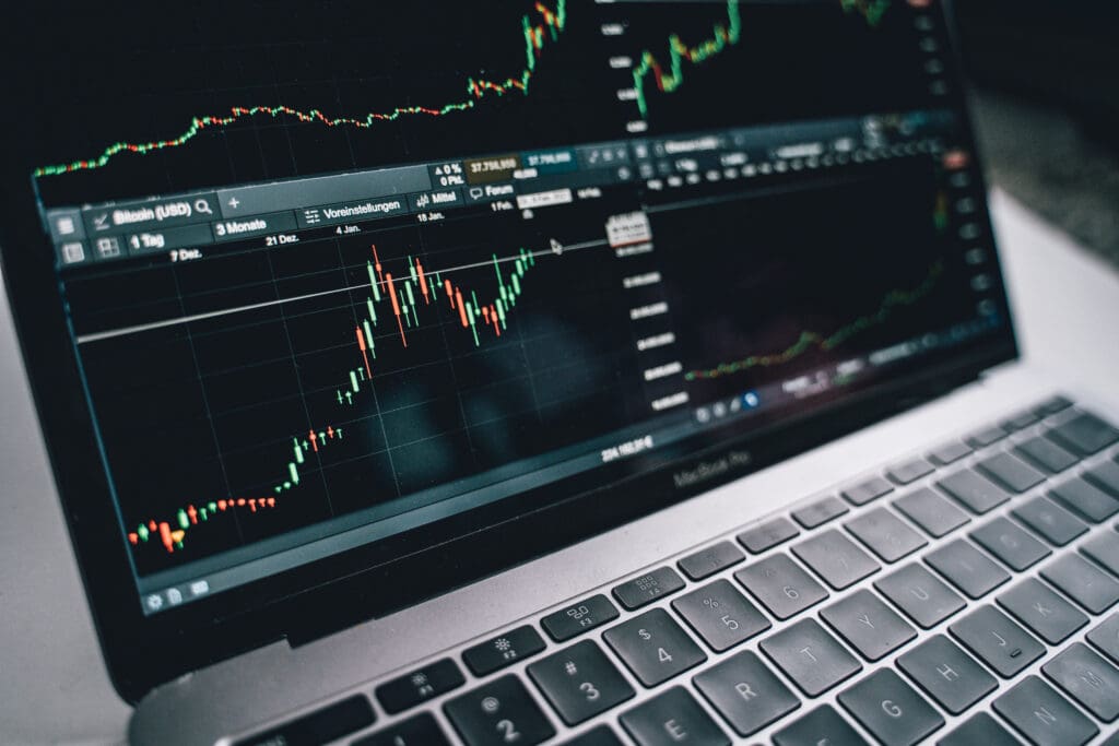 Black and silver laptop with stock market display on screen