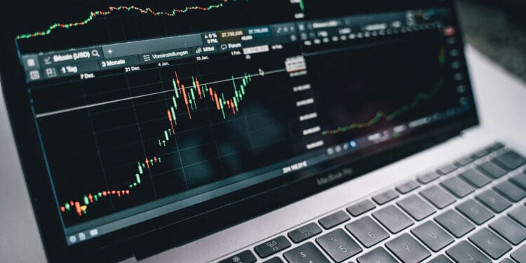 Black and silver laptop with stock market display on screen