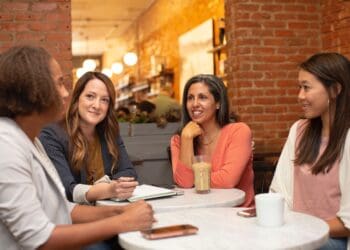 Four women working in a business meeting in a cafe coffee shop