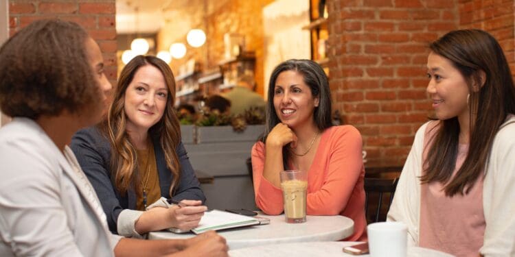 Four women working in a business meeting in a cafe coffee shop