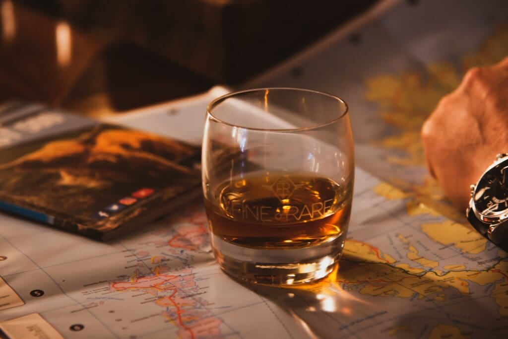 Glass of whisky on top of map.