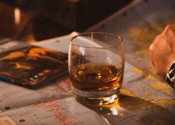 Glass of whisky on top of map.