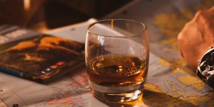 Glass of whisky on top of map.