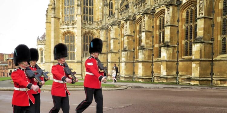 Red Uniformed guardsmen march before the Queen of England arrives to Sunday Easter Service at Windsor Palace in London, United Kingdom